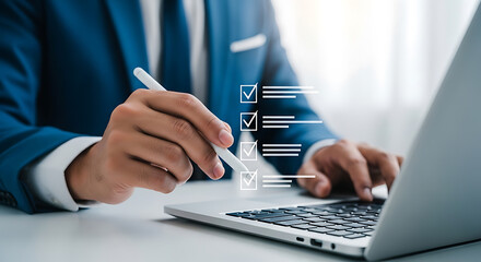 Fototapeta premium Businessman using stylus on laptop to complete checklist, indicating tasks completed and business process management.