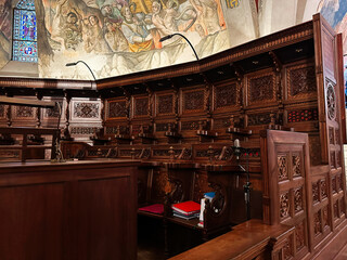 Fototapeta premium Ornate wood paneling and historic church pews in Assisi Italy create a sacred interior scene