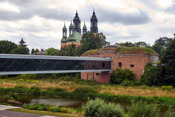 Modern footbridge over the Warta River, Prussian fortifications, and towers of the Gothic cathedral in Poznan