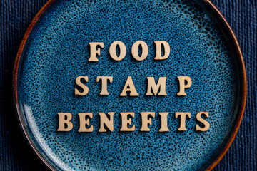 The inscription on the blue plate about food stamp benefits, closeup. The Supplemental Nutrition Assistance Program, known as the Food Stamp Program, is a United States federal government program
