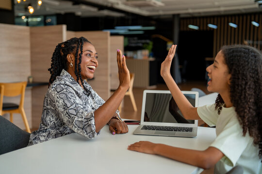 African school teacher is teaching and guiding young student and having high five in the class using information from experience and internet for academic literacy study and education usage