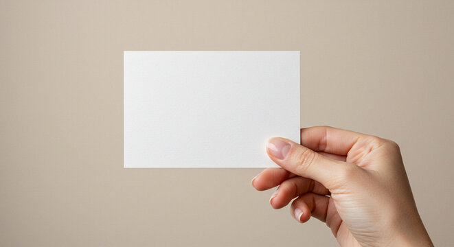 A hand holds a blank white card or invitation against a simple, neutral background. A clean, minimalist, and versatile mockup for stationery or branding presentations.