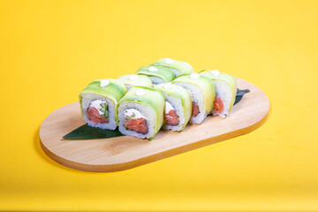 High-quality close-up of fresh salmon and tuna sushi rolls served on a black ceramic plate. Ideal for Japanese restaurant menu design.