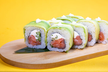 High-quality close-up of fresh salmon and tuna sushi rolls served on a black ceramic plate. Ideal for Japanese restaurant menu design.