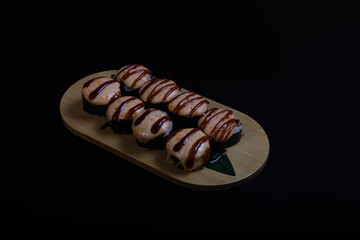 Delicious Japanese sushi set with nigiri, maki rolls, and soy sauce served on a wooden board. Traditional Asian cuisine concept.