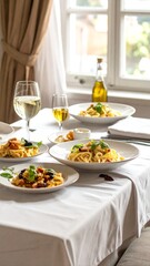 Pasta lunch on table with white wine.