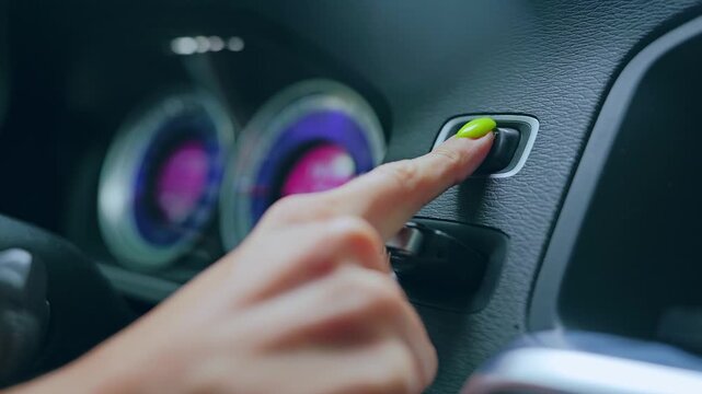 Modern car dashboard and female finger starting engine in elegant slow motion