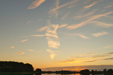 Sunset at the lake, reflection, tranquility and golden tones in the evening sky