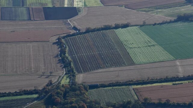 Aerial view of various agricultural fields displaying a patchwork of textures and tones, showcasing the rural landscape, Rouffach, Grand Est, France.