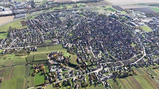 Aerial view of the compact Rouffach townscape featuring buildings, roads, and greenery, framed by agricultural fields in the French countryside, Rouffach, Grand Est, France.