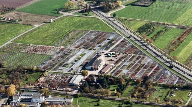 Aerial view of fields bisected by a highway, showcasing a mix of green fields and structured agricultural plots, Rouffach, Grand Est, France.