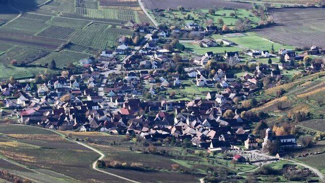Aerial view of a village nestled among vineyards, with a church standing out against the rooftops, Rouffach, Grand Est, France.