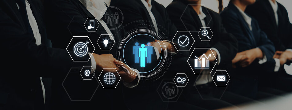 A group of business professionals in suits participates in a corporate meeting, surrounded by digital icons symbolizing networking and teamwork concepts. Trope - Powered by Adobe