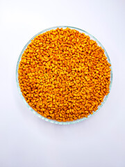 Top view orange masterbatch granules in a glass dish, isolated on a white background, with space for text, suitable for product catalog design of a manufacturing company profile