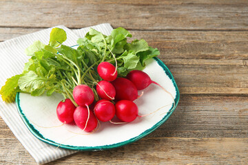 Fresh ripe radishes on wooden table, space for text