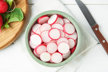 Fresh ripe radishes and knife on white wooden table, flat lay