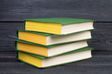 Books on wooden table, black board background. Back to school. Education business concept.