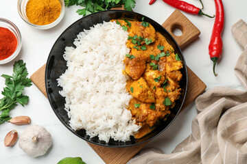Chicken tikka masala with rice served on white marble table, flat lay