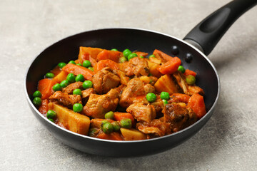 Delicious cooked stew in frying pan on grey table, closeup