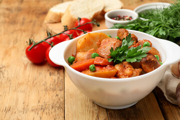 Delicious cooked stew served on wooden table, closeup