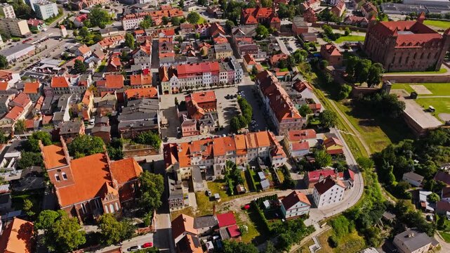 Drone shot showing medieval Gniew castle and colorful houses in summer