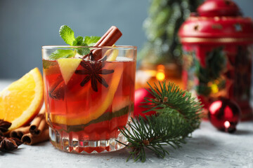 Tasty punch drink, spices and Christmas decor on light table, closeup