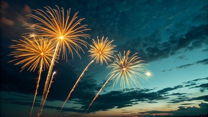 A dazzling night sky illuminated by golden-yellow fireworks bursting in radiant patterns. Their glowing trails and vibrant light contrast beautifully with the deep blue and teal hues of the evening sk