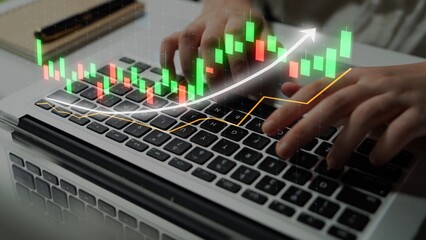 Close-up of hands typing on a laptop with a colorful stock market graph overlay, highlighting growth trends and trading analytics in a modern workspace. Copula
