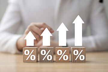Interest rates rising concept with percentage symbol on wooden blocks and up arrows business finance