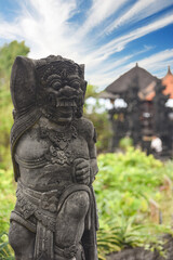 religious stone barong gatekeeper mask sculpture at entrance to Tanah Lot, Bali, Indonesia