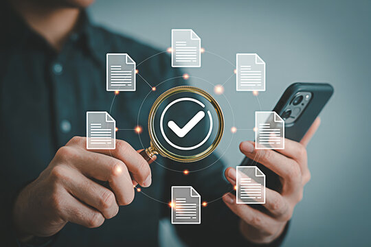 Document verification approval process with magnifying glass and smartphone for data analysis audit check