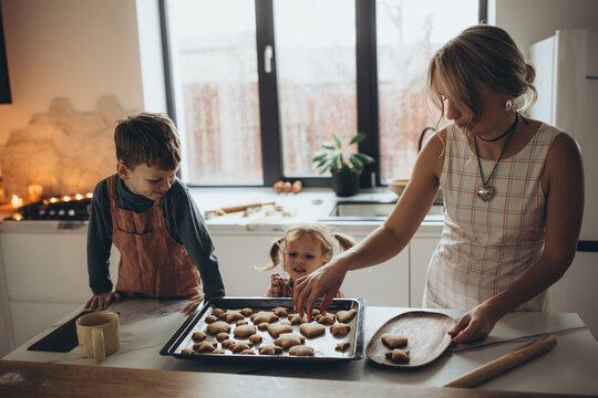 A mother and her children are preparing delicious food in the kitchen on the eve of the holiday. Children and their mother are cooking