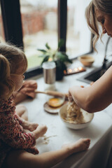 A mother and daughter are cooking in the kitchen. A mother and daughter are spending the pre-holiday evening cooking.