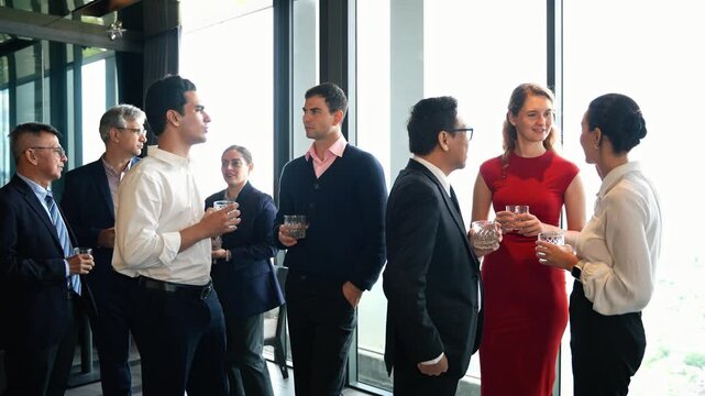 Diverse group of happy business professionals networking and socializing at a corporate cocktail event or New year party. Colleagues enjoy conversation and build relationships during meeting at lounge