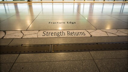 Text on Floor Tile Reinforcing Resilience and Recovery with Fracture Edge Words in Urban and Creative Space