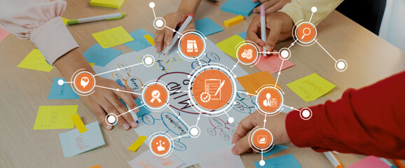 A vibrant brainstorming session with diverse hands collaborating over colorful sticky notes and organized ideas on large paper, emphasizing creativity and effective teamwork. Amity