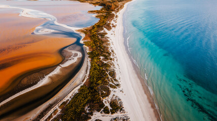An aerial photograph of a coastal landscape divided into three distinct sections