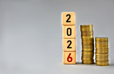 2026 - numbers on wooden cubes against a background of stacks of coins
