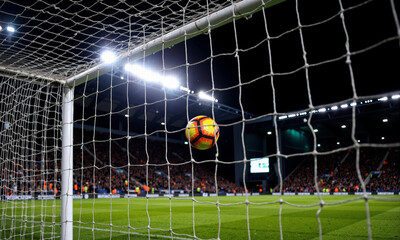 Soccer ball hitting the net in nighttime stadium during match  