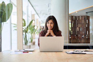 Latin hispanic business woman financier manager working on laptop computer in office, looking at...