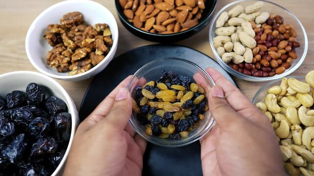 Hands Holding Mixed Raisins with Nuts and Dried Fruits