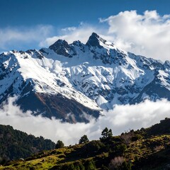Majestic snowy mountain peak rising above fluffy clouds and a lush green hill