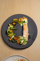 A plate of salmon with vegetables.