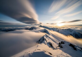 Snow covered mountains with clouds and sunlight on a clear day