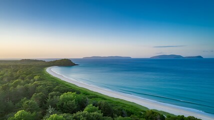 Aerial view of beautiful sandy beach with lush green vegetation and turquoise ocean under blue sky