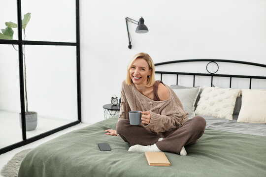 Blonde woman enjoys cozy moments at home in a modern apartment for winter self-care