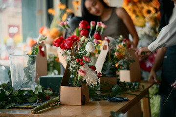 Group of people arranging colorful flowers together focus on flower
