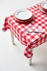 Classic Red and White Gingham Diner Tablecloth Overhead flat lay of a pristine, folded red and white gingham diner tablecloth. Sharp focus, studio lighting, plain white background. No people or hands.