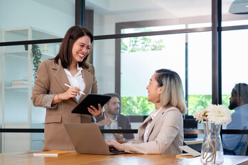 businesswoman manager in formal suit discuss market share with colleague coworker at finance office, employee team meeting collaborate on progress brainstorm spread idea working together