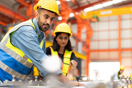 engineer worker man in safety vest and helmet check material with blueprint, people working in industrial manufacturing factory planning to inspect repairing equipment in production warehouse - Powered by Adobe
